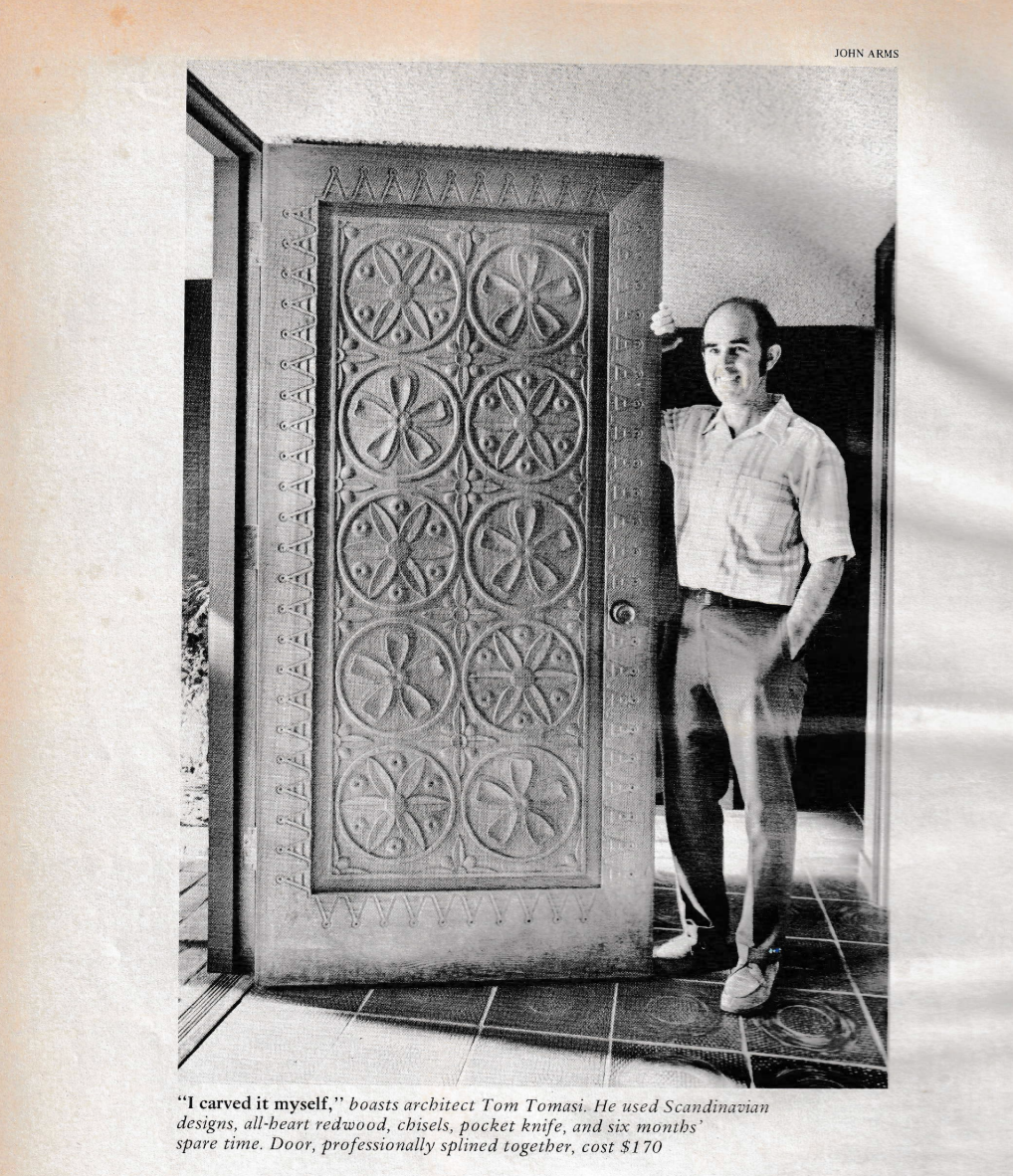 Tom Tomasi beside the front door he carved by hand