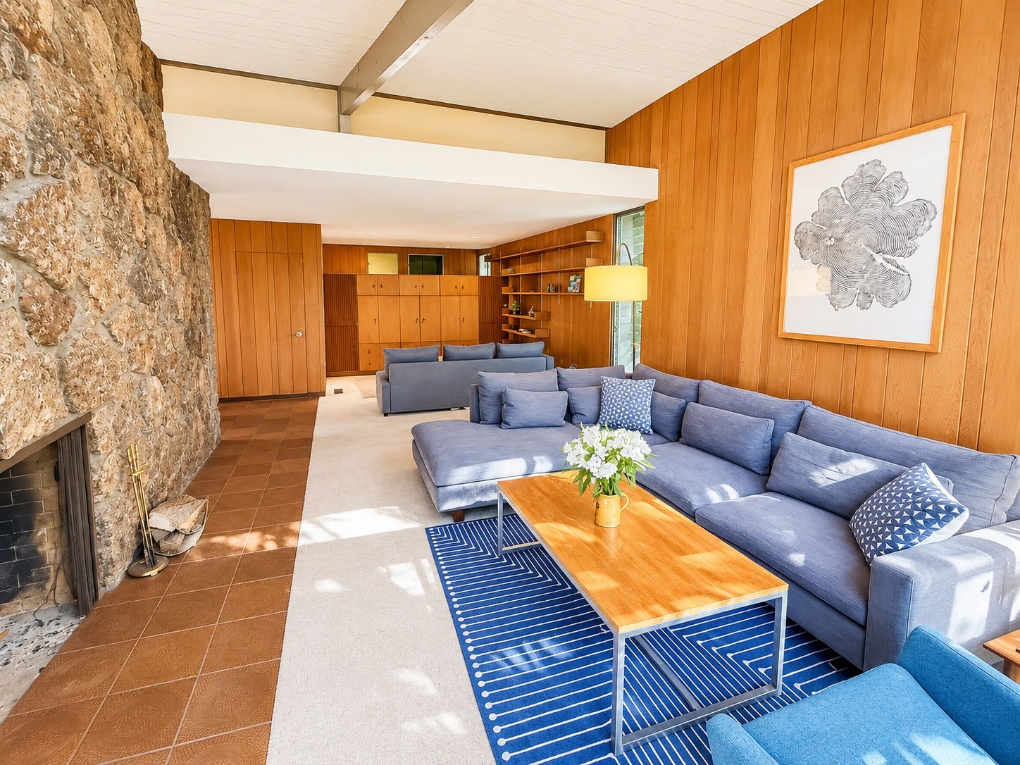 Wood-paneled living room with blue sectional sofa